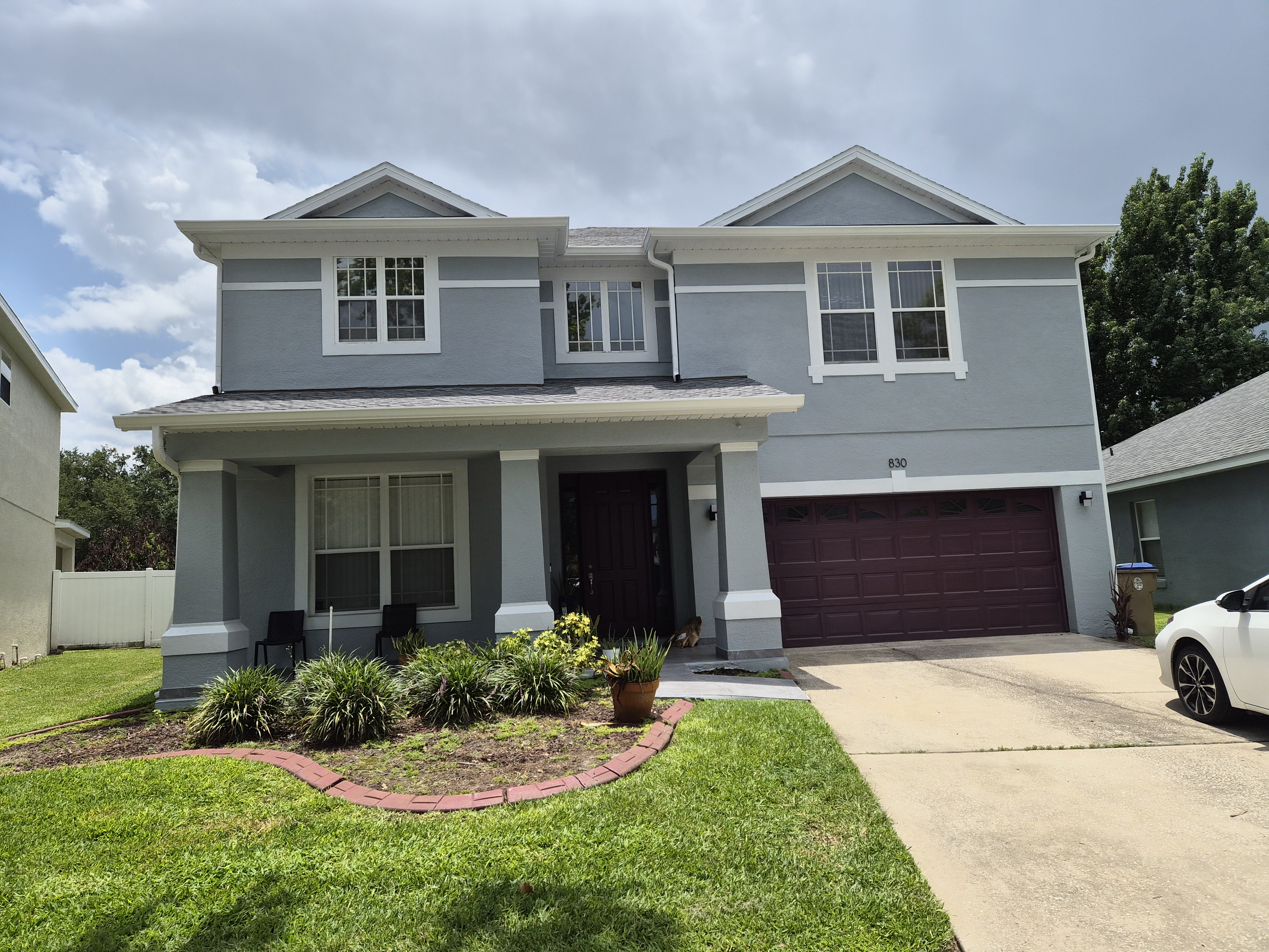 Two-story Florida home with white seamless gutters by M12 Gutters