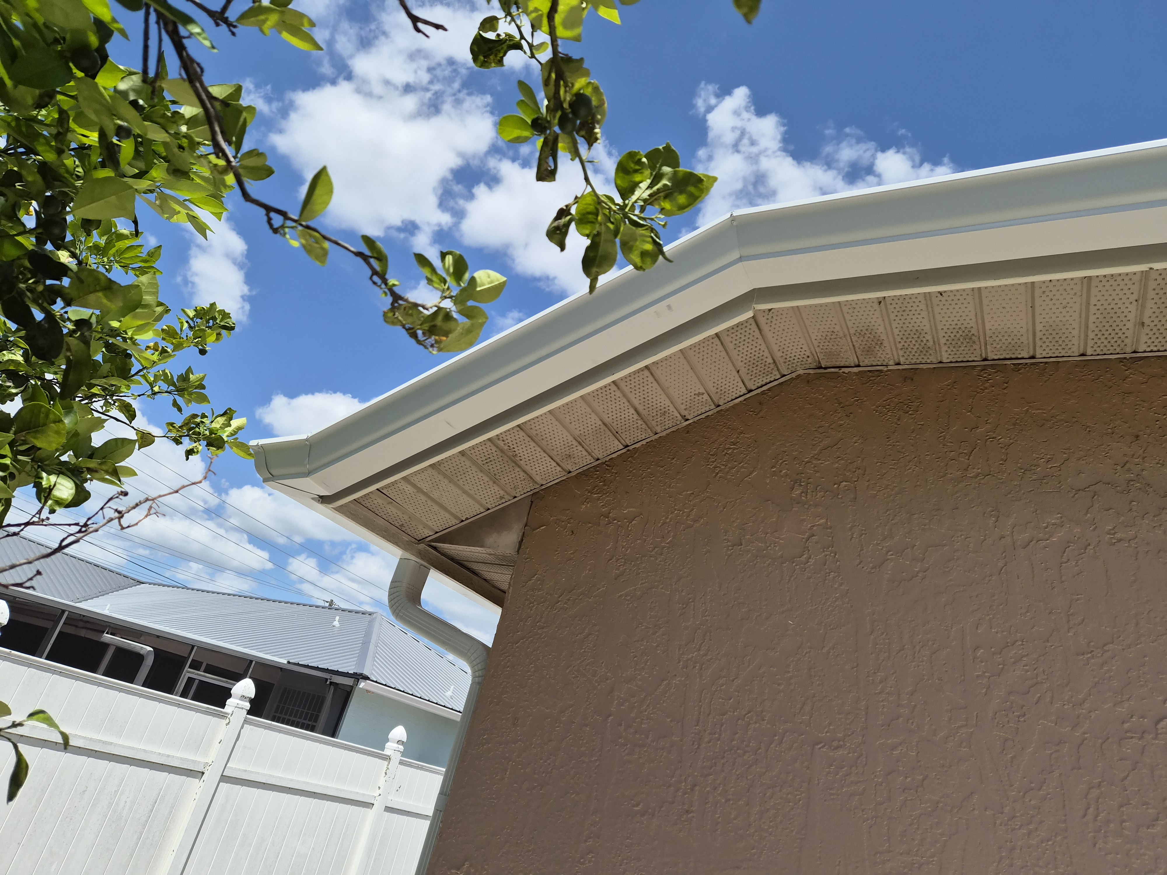 Close-up of white seamless aluminum gutters with soffit installed by M12 Gutters